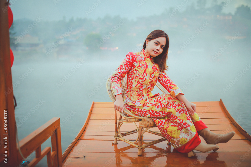 Beautiful Asian Chinese Woman Wearing Cheongsam Traditional Red Dress on Chinese New Year travel on vacation Posting on a boat in the river. Beautiful Asian Chinese Woman Wearing Cheongsam Traditional Red Dress on Chinese New Year travel on vacation Posting on a boat in the river.