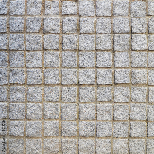 Square stone ground texture background. Cobblestone pavement as road, approach, entrance, and garage.