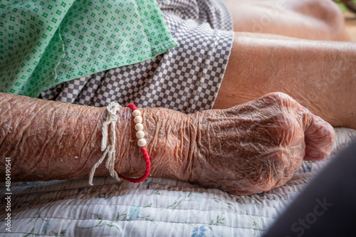 Close up wrinkled skin of old senior woman hands, bedridden patient