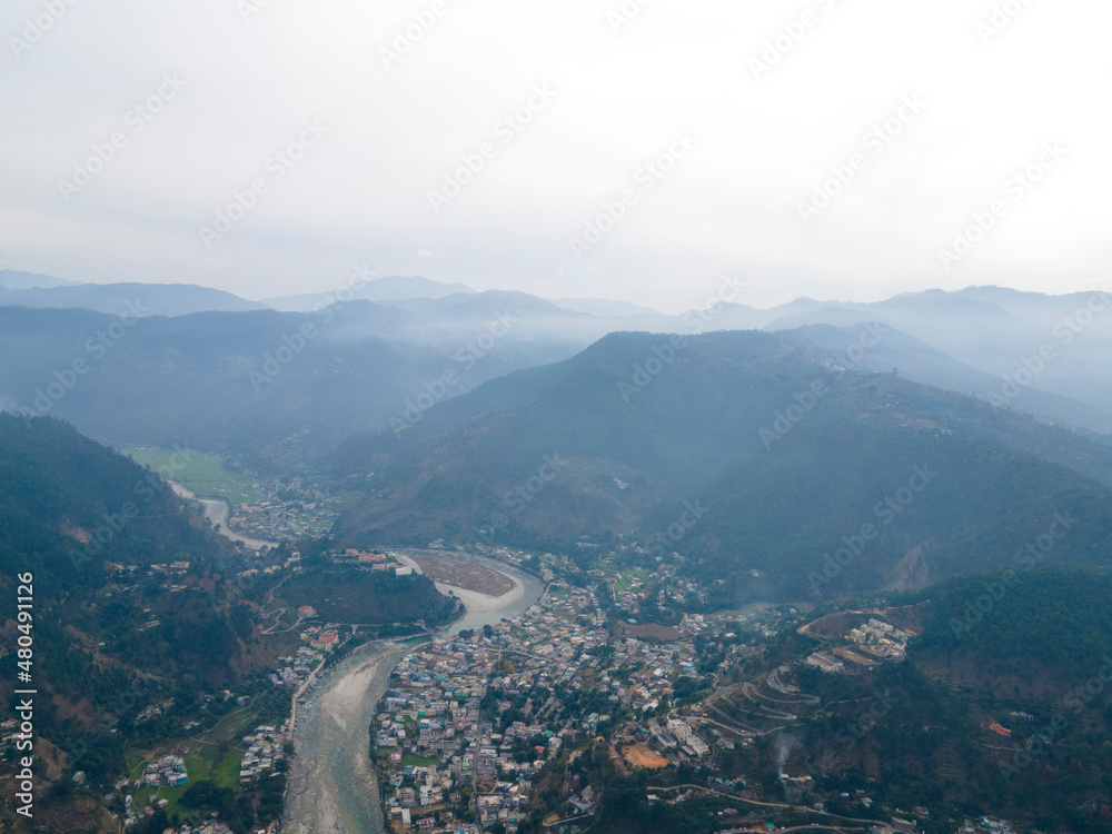 Aerial view of Bageshwar city in uttarakhand. Drone shot of a city situated in the banks of a river in mountains.