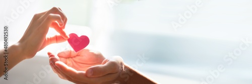 Woman Giving Heart On Man's Hand