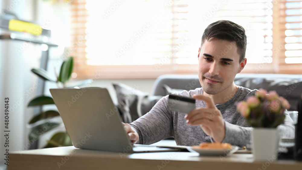 Handsome man making payment online or banking online with computer laptop. Handsome man making payment online or banking online with computer laptop.