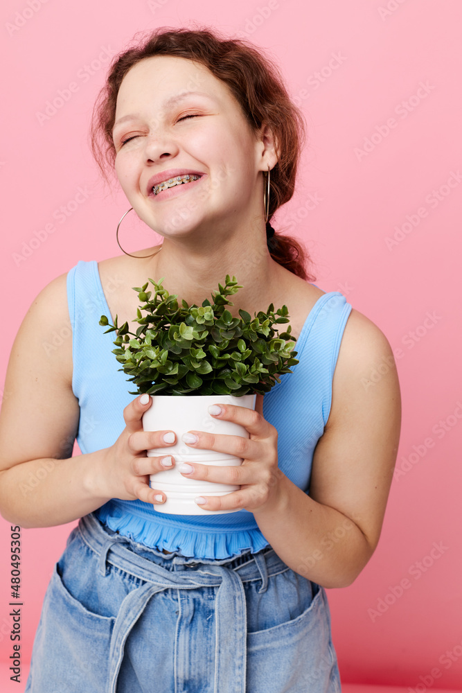funny girl in a blue T-shirt and shorts a flowerpot isolated backgrounds unaltered funny girl in a blue T-shirt and shorts a flowerpot isolated backgrounds unaltered