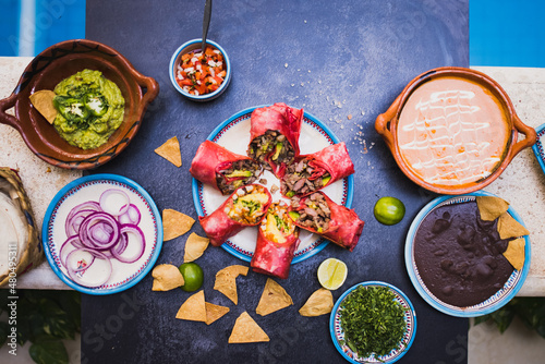 Delicious traditional Mexican condiments and dishes on dark surface