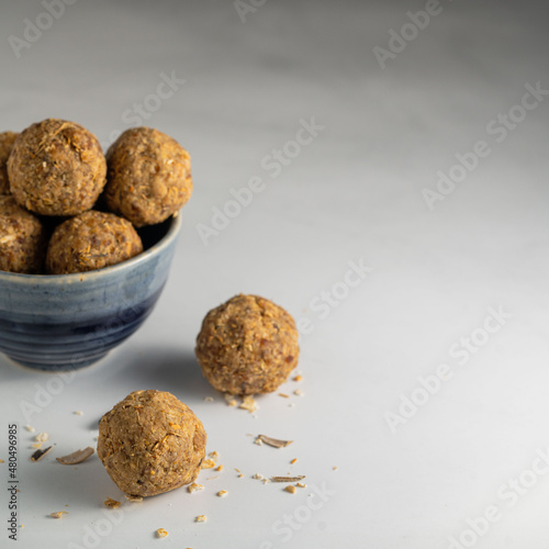 Peanut butter, sunflower seed and date energy balls on a white background. 