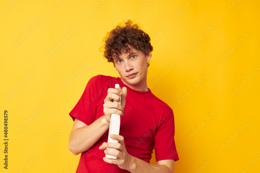 Young curly-haired man detergent posing emotion yellow background unaltered