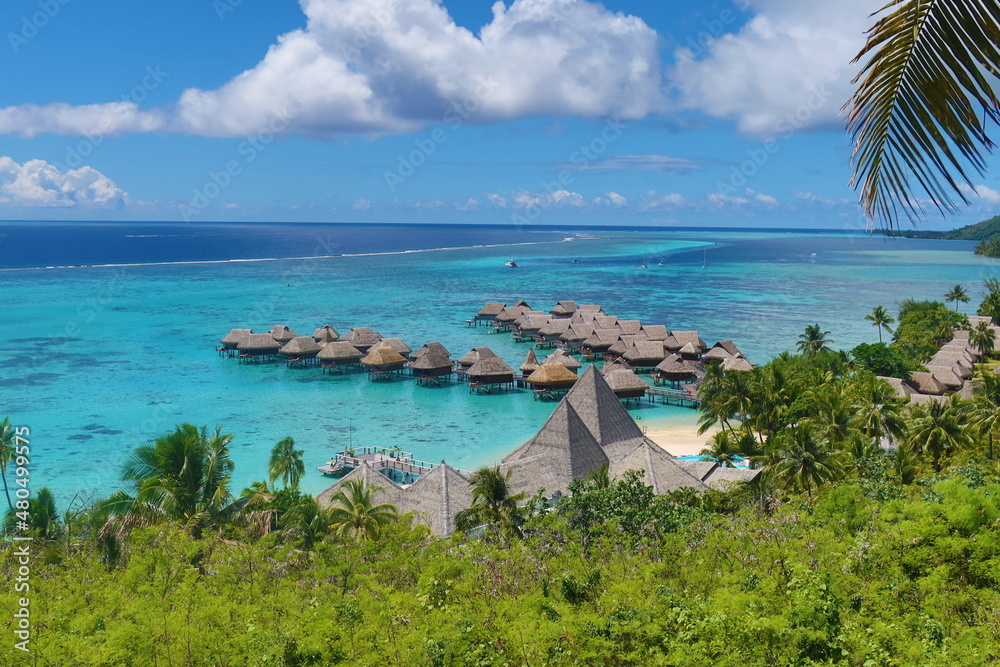 Magnifique lagon bleu turquoise avec des bungalows pilotis sur une île paradisiaque 