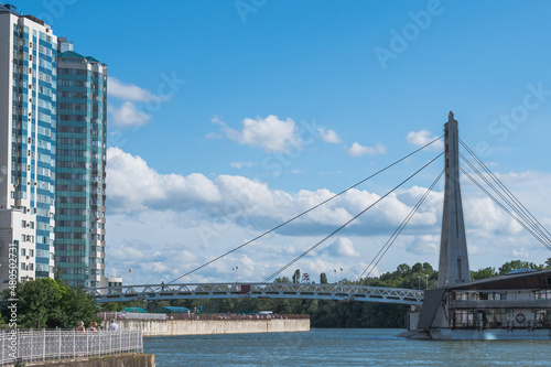 Cable-stayed bridge over the Kuban River and a multi-storey house on the embankment. Urban landscape © VeNN