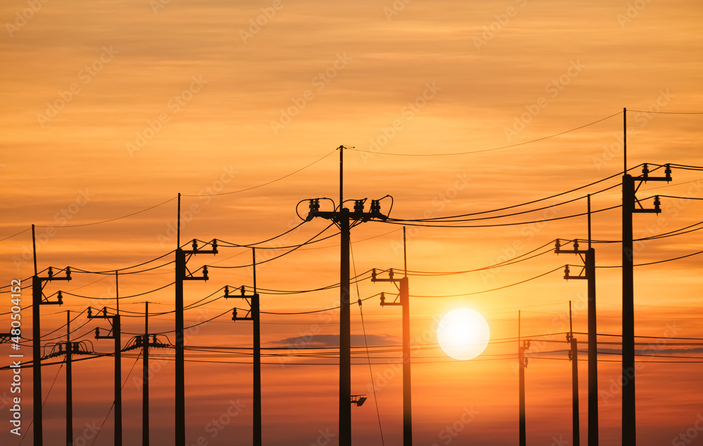 Silhouette row of electric power poles against colorful sunset sky background