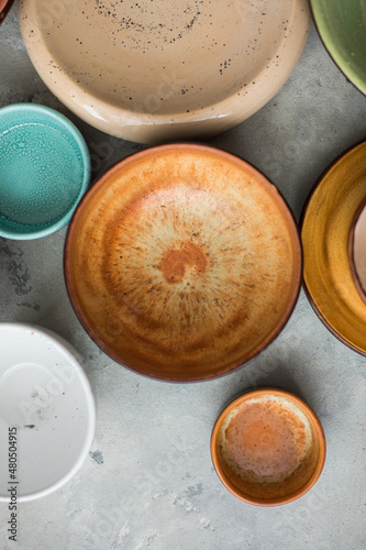Ceramic plates and cup on wooden surface. Overview empty food table with tableware. 