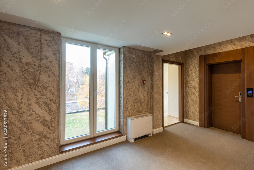 Obraz premium Interior of a carpeted hotel corridor doorway with brown wooden doors