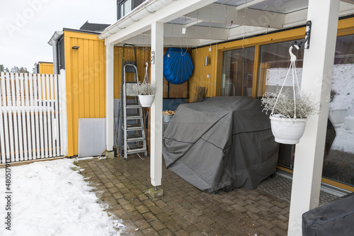Summer furniture under cover, on  backyard of private house on winter day. Sweden. © Alex