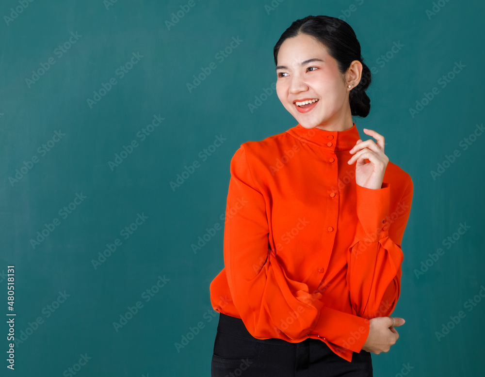 Portrait studio shot of Asian beautiful professional bun hairstyle female teacher or college student in red formal outfit standing crossed arms smiling look at camera on green chalkboard background Portrait studio shot of Asian beautiful professional bun hairstyle female teacher or college student in red formal outfit standing crossed arms smiling look at camera on green chalkboard background