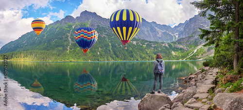 Young girl looks at hot air balloons over Morskoe Oko lake, Sea eye, Poland photo