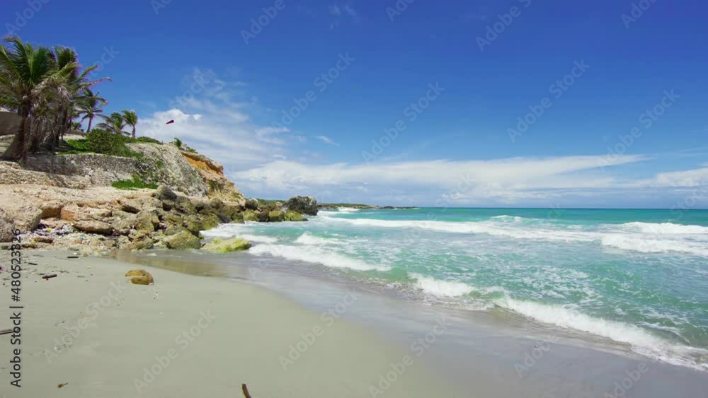 Sea waves on a sandy beach littered with plastic. Plastic waste pollutes the environment and causes an ecological disaster for the planet.