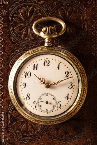 106= Old classic antique pocket watch on leather bible background
