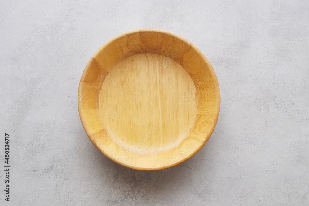 Empty round wooden plate on gray cement table background, banner with copy space for food display montage, template, mock up, top view, flat lay Empty round wooden plate on gray cement table background, banner with copy space for food display montage, template, mock up, top view, flat lay