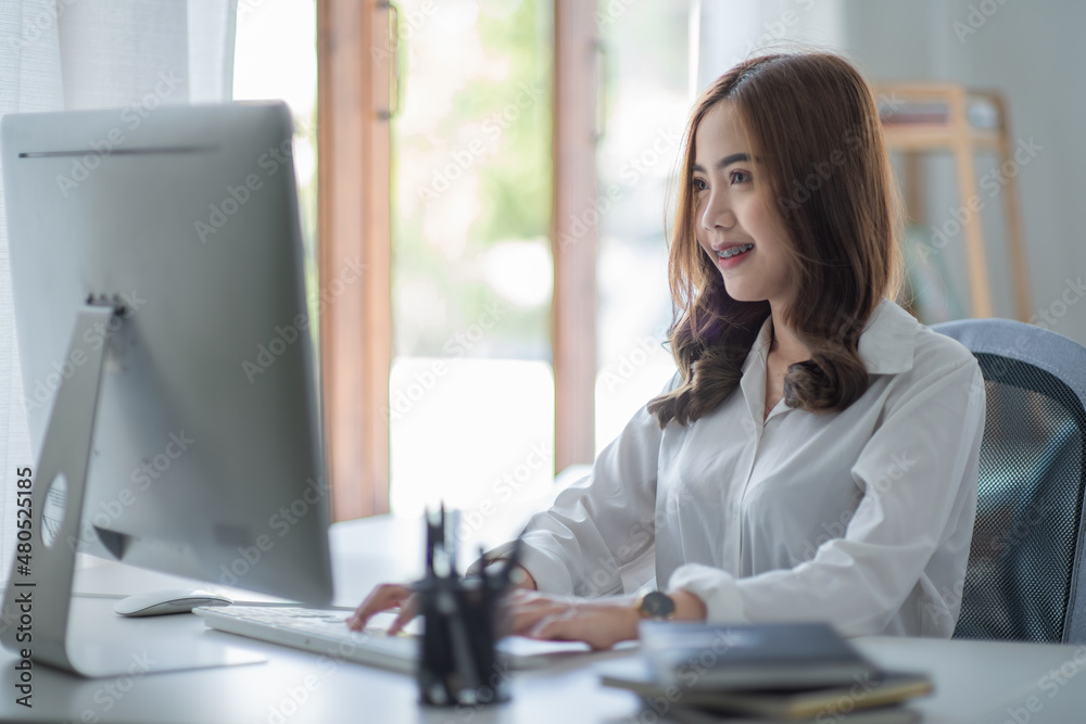Portrait of smiling beautiful business Asian woman with working in modern office desk using computer, Business people employee freelance online marketing e-commerce telemarketing concept. Portrait of smiling beautiful business Asian woman with working in modern office desk using computer, Business people employee freelance online marketing e-commerce telemarketing concept.