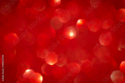 Abstract festive blurred red background texture with bokeh circles and lights for Valentine or wedding day. Card concept. Space for design.