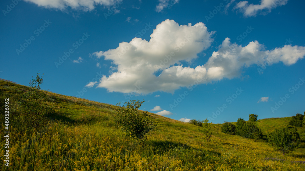 White clouds and flowering meadows among the hills. White clouds and flowering meadows among the hills.