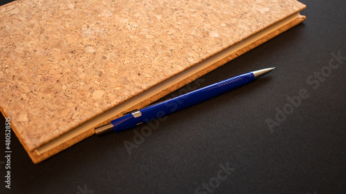 Korkowy zeszyt i niebieski długopis