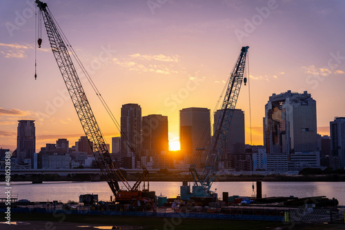 Sunrise over Osaka City and Construction Cranes on the Yodogawa River, Japan