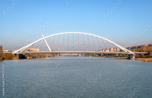 Panoramic view of Barqueta Bridge, a tied arch bridge which spans the Alfonso XIII channel of the Guadalquivir river in Seville, Andalusia, Spain.