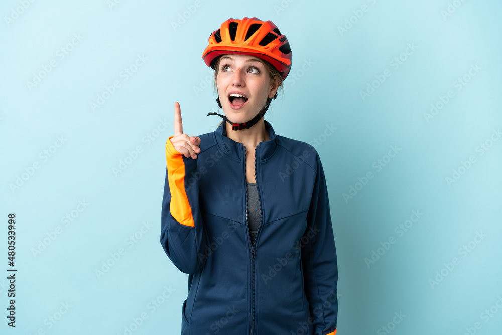 Young cyclist woman isolated on blue background thinking an idea pointing the finger up Young cyclist woman isolated on blue background thinking an idea pointing the finger up