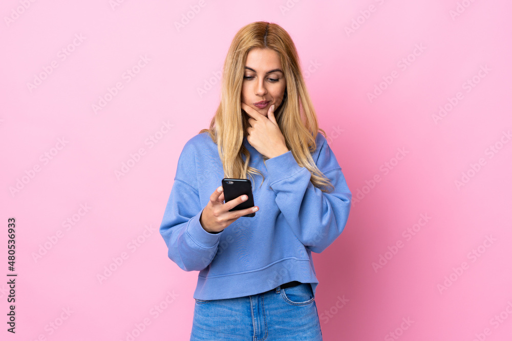 Young Uruguayan blonde woman over isolated pink background thinking and sending a message Young Uruguayan blonde woman over isolated pink background thinking and sending a message