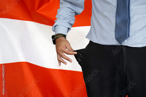 Man turns up his trouser pocket on the background of the Austria flag