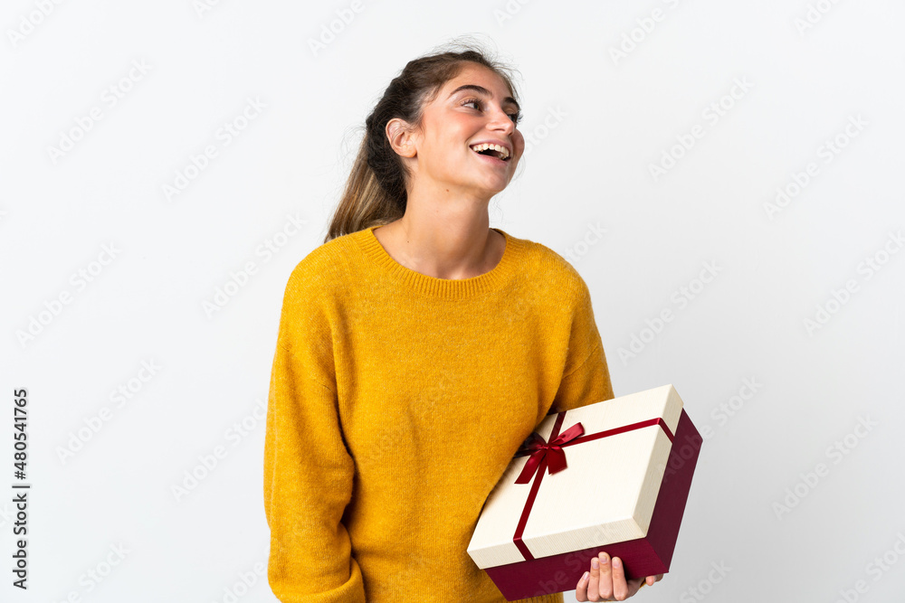 Young woman holding a gift isolated on white background laughing Young woman holding a gift isolated on white background laughing