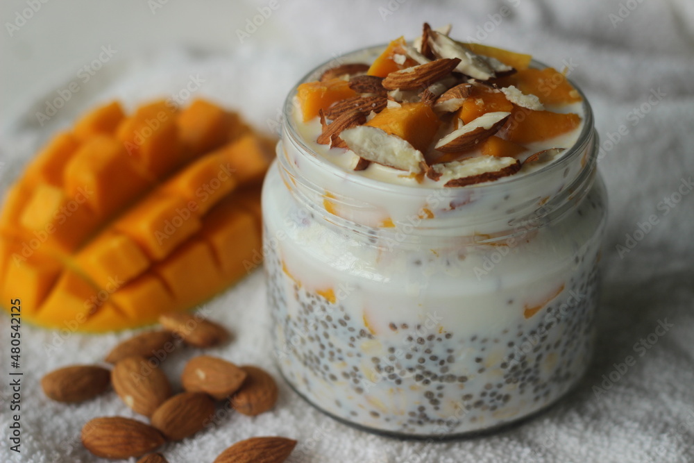 Overnight oats with mango and almonds. Made by soaking rolled oats and chia seeds in milk served with chopped mangoes, almonds and honey Overnight oats with mango and almonds. Made by soaking rolled oats and chia seeds in milk served with chopped mangoes, almonds and honey