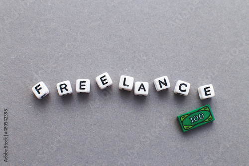 word freelance made from plastic cubes of beads on gray background