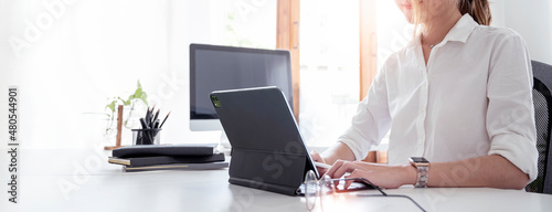 Young business woman using computer at office. Croppe image, panoramic background. photo