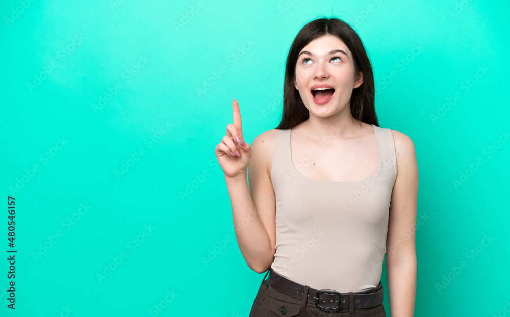 Fototapeta premium Young Russian woman isolated on green background pointing up and surprised