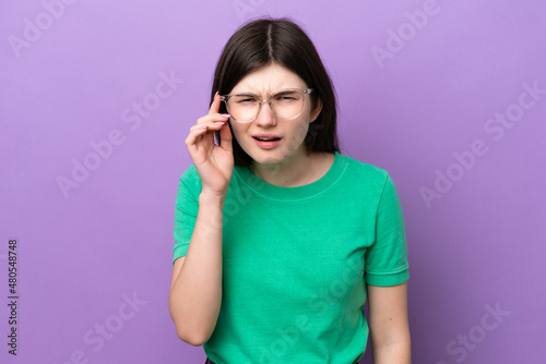 Young pretty Russian woman isolated on purple background With glasses and frustrated expression