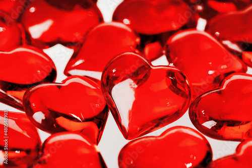 St Valentines day full frame background. Many red glass hearts closeup. Love or wedding concept. Selective focus