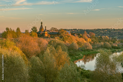 October countryside landscape with river and church at sunset