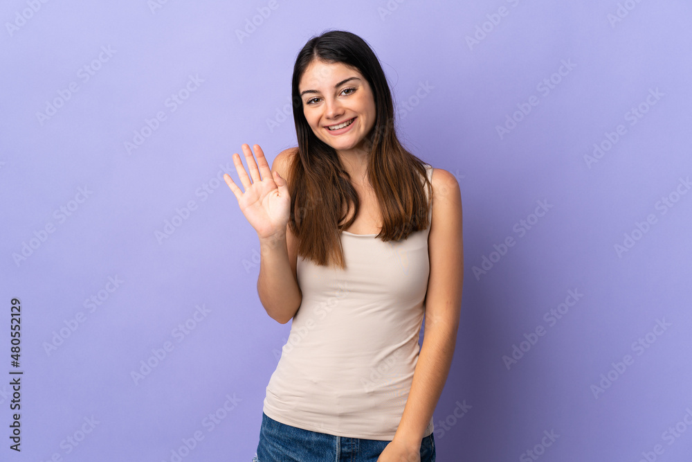 Young caucasian woman isolated on purple background saluting with hand with happy expression Young caucasian woman isolated on purple background saluting with hand with happy expression