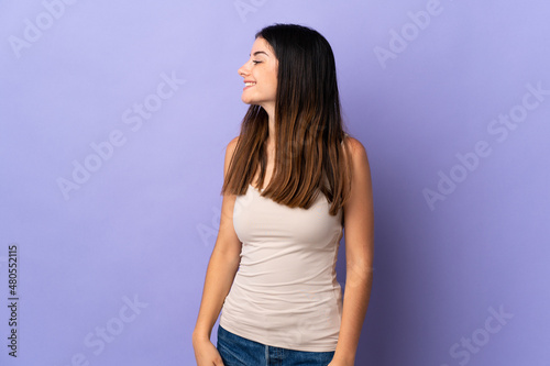 Young caucasian woman isolated on purple background laughing in lateral position