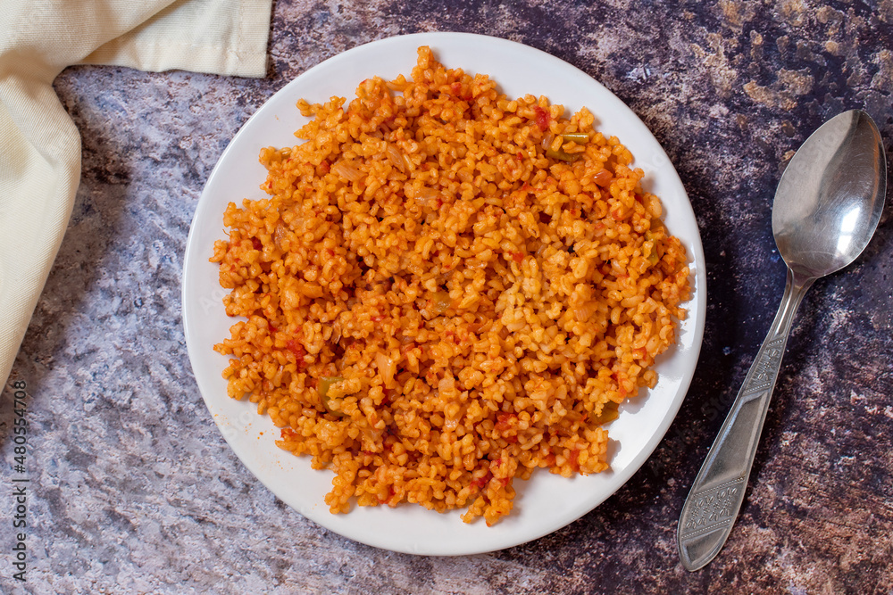 Bulgur pilaf on a dark background. Close-up of Turkish food Bulgur Pilav in a ceramic plate. Top view Bulgur pilaf on a dark background. Close-up of Turkish food Bulgur Pilav in a ceramic plate. Top view
