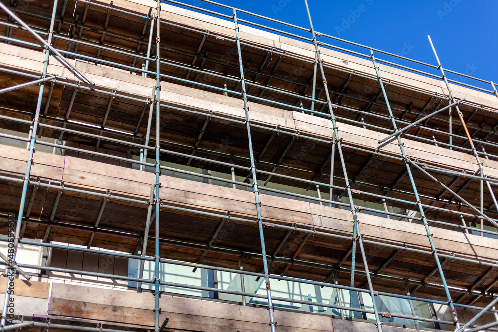 Metal scaffolding building frame with wooden boards platform on an industry construction site, stock photo image