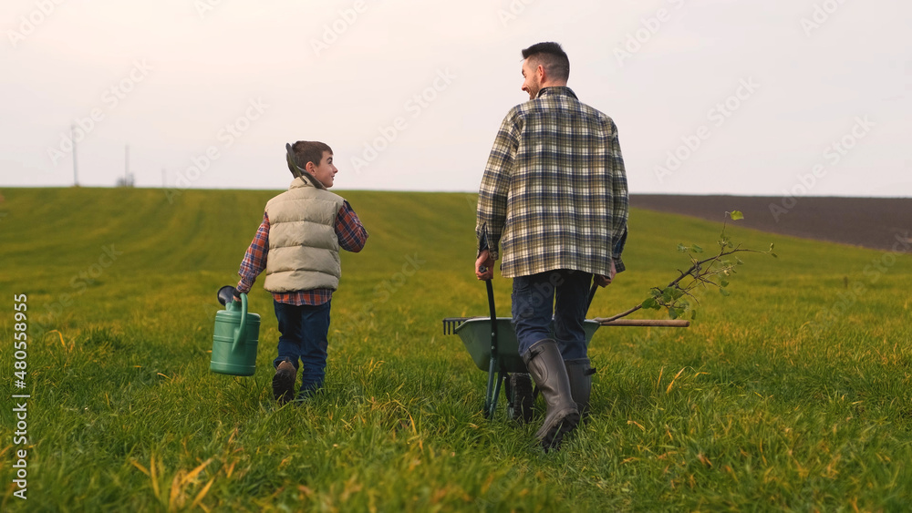 The farmer with his son walking through the field