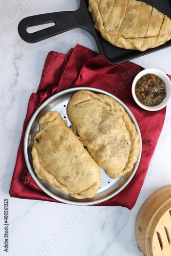 Himachal Pradesh special dish siddu. It's a steamed wheat flour bread stuffed with split black gram lentils, dry fruits, poppy seeds, walnut etc. Served with ghee and tomato chutney. Copy space photo