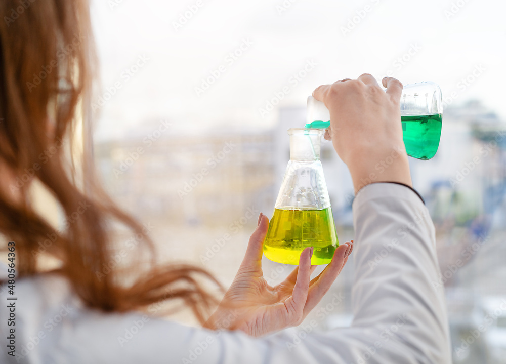 A girl laboratory assistant mixes reagents in a chemical laboratory A girl laboratory assistant mixes reagents in a chemical laboratory