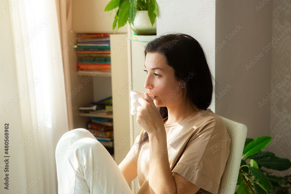 Attractive young woman enjoying coffee and relaxing at home. Attractive young woman enjoying coffee and relaxing at home.