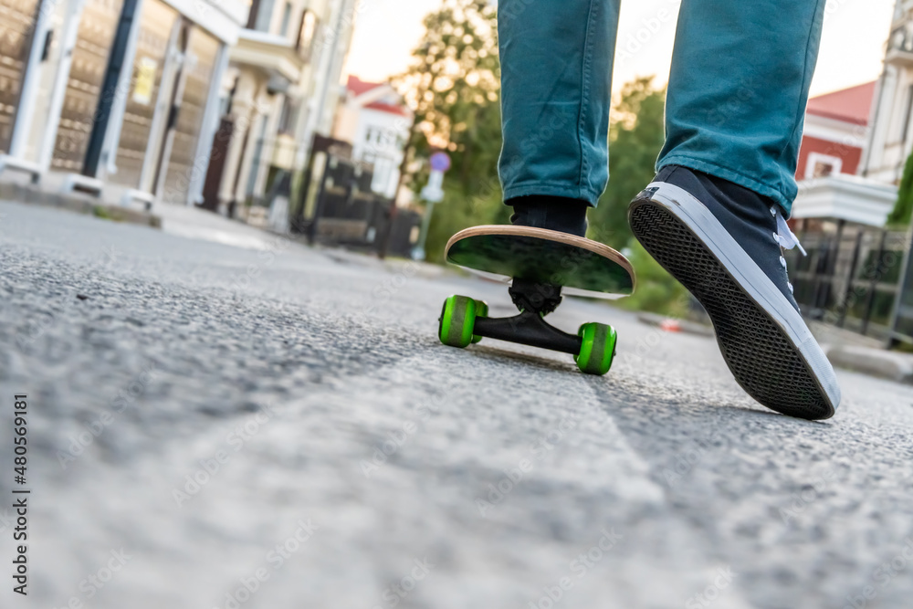 Obraz premium Legs of a man on a skateboard on the street