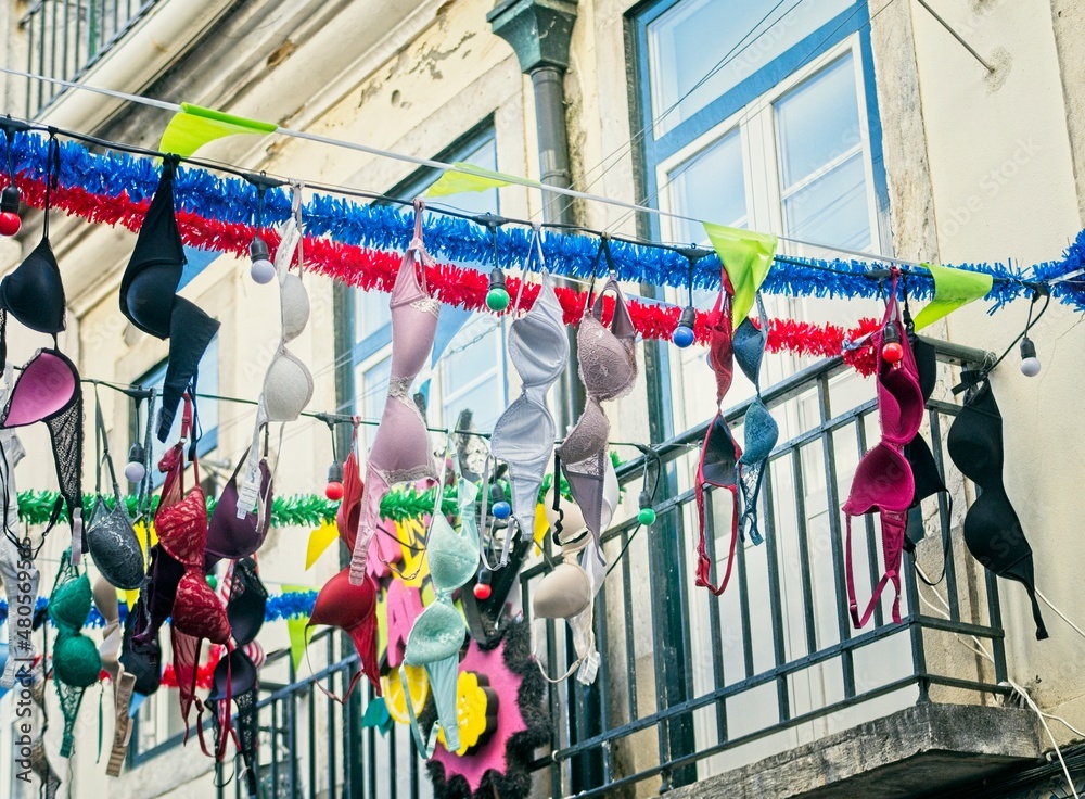 Artistic street banner with colorful women's bras in the Bairro Alto neighborhood in Lisbon, Portugal.