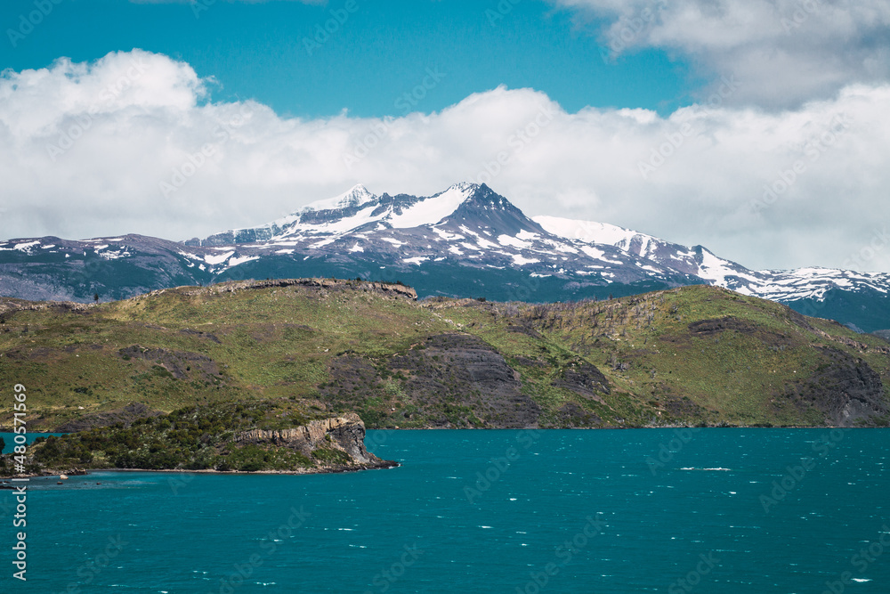 Lake in mountainous area with snowy mountain tops in the background in Chilean Patagonia
