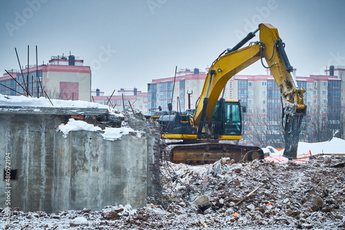 Demolition of old concrete building. Hydrohammer crushes building photo